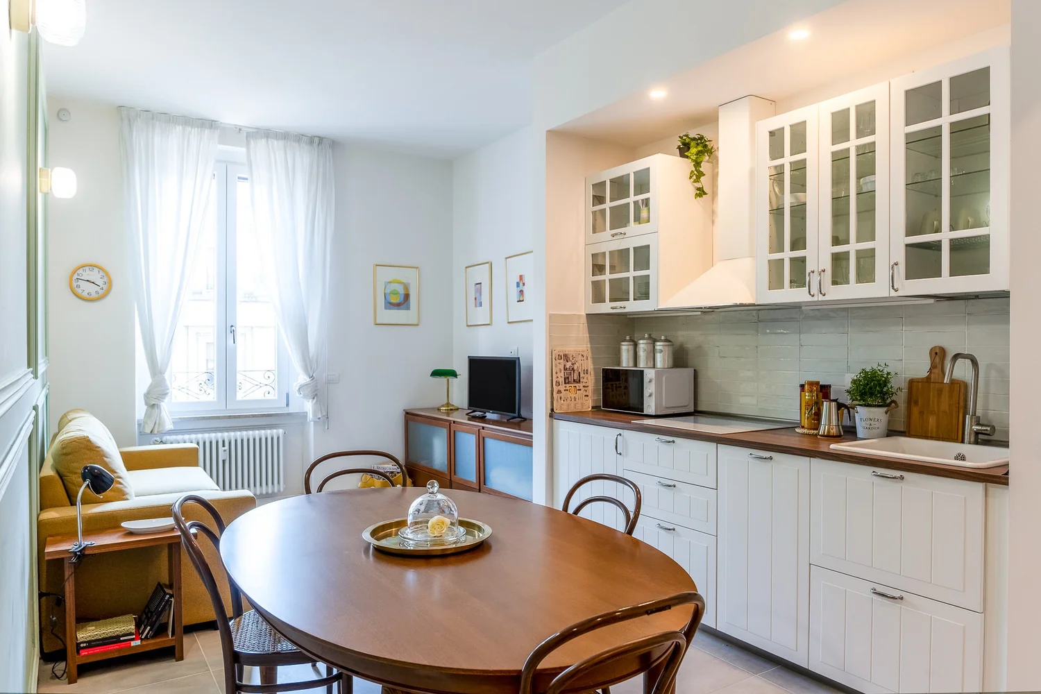 Open kitchen with round dining table and modern cabinetry in a Townhomes Milano Mid-Century Modern apartment