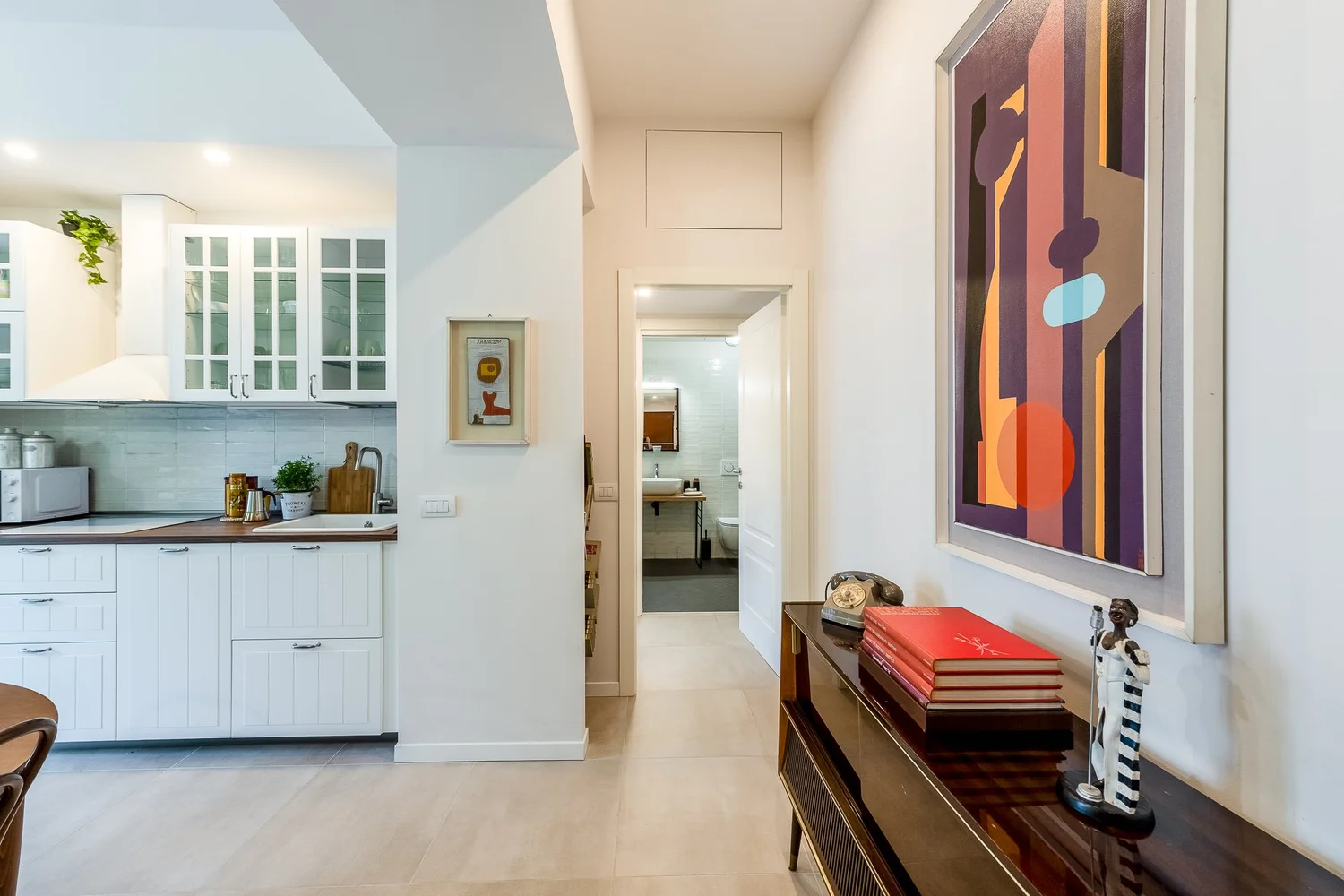 Hallway with bench seating and wall art inside a Townhomes Milano Mid-Century Modern apartment