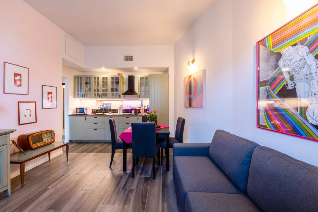 Open-plan living room and kitchen with warm lighting inside the Colorful Eclectic apartment by Townhomes Milano.