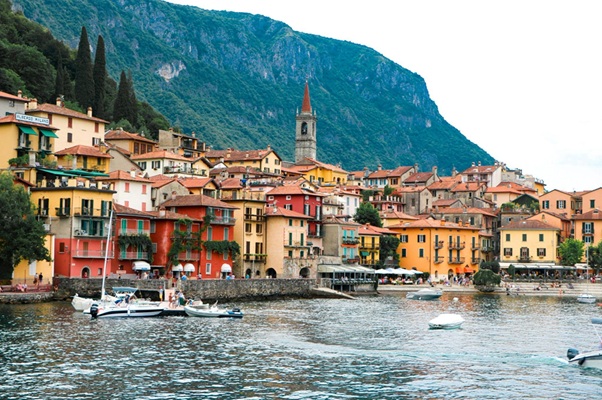 Colorful waterfront houses and mountain scenery in Lake Como on an easy day trip from Milano Centrale railway station for guests staying at Simone Urban Organic in Milan.