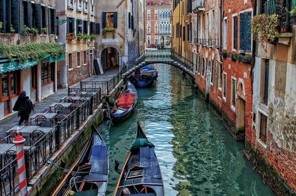 Scenic canal with gondolas along the waterways of Venice on an easy day trip by train from Milano Centrale train.