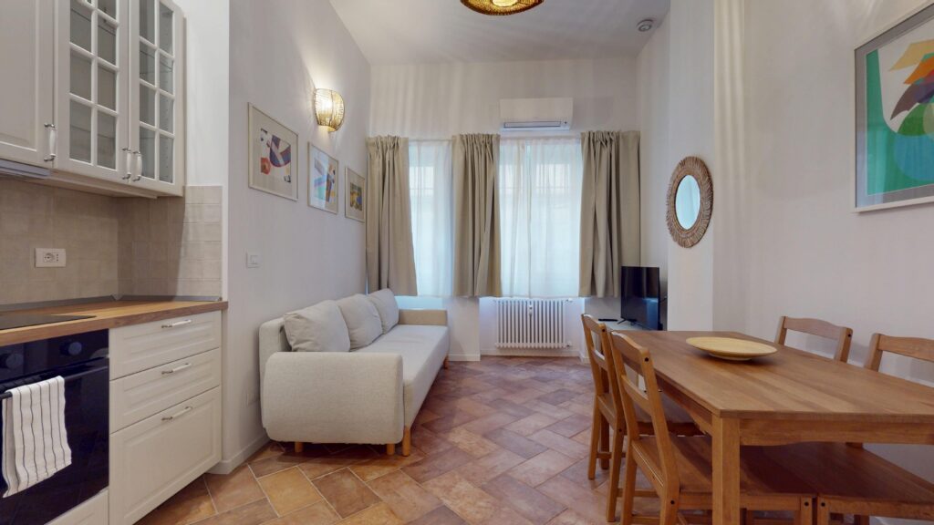 A bright apartment lounge featuring a comfortable white sofa and traditional parquet flooring, ideal for a relaxing rental stay in Milan, Italy, by Townhomes Milano for international tourists and travelers.