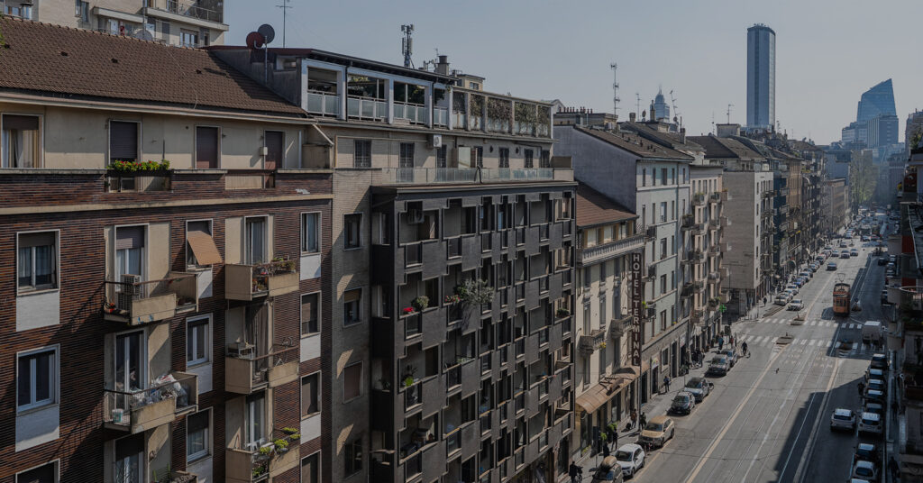 City street view in Milan with historic buildings and modern architecture, illustrating travel safety tips; banner created with Canva AI.