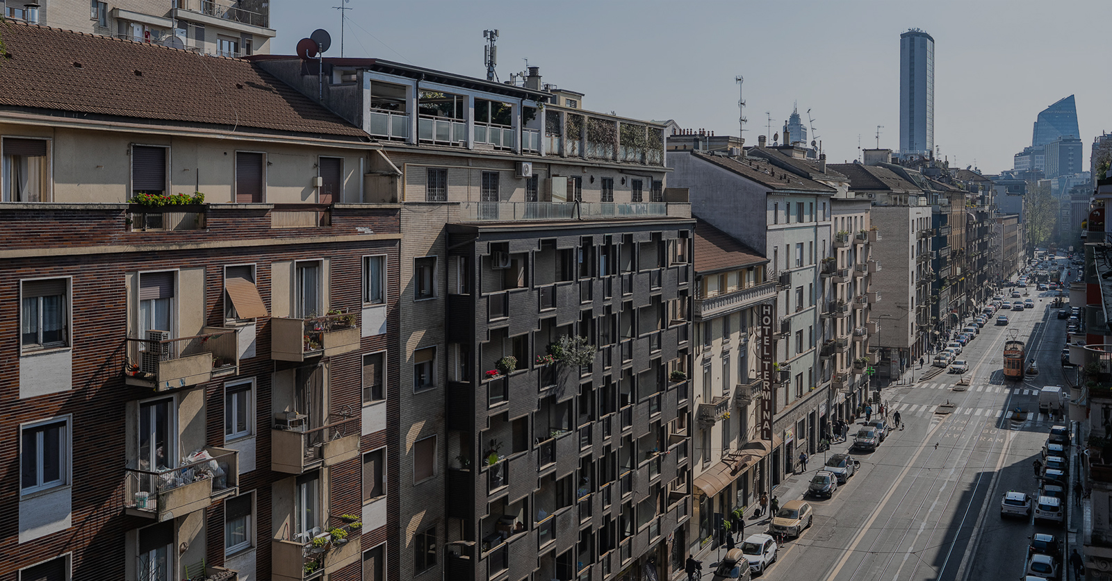 City street view in Milan with historic buildings and modern architecture, illustrating travel safety tips; banner created with Canva AI.