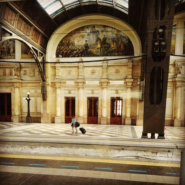 Spacious historic building interior with arched windows and marble floors in Milan.
