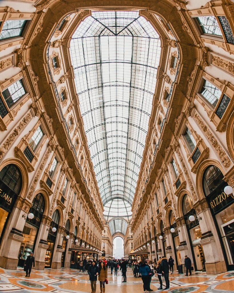 Interior view of the glass-vaulted ceiling of Galleria Vittorio Emanuele II, a premier destination for luxury shopping and architecture in Milan.