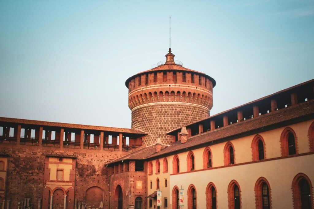 External view of the historic red-brick Sforzesco Castle, a major cultural landmark and museum hub in central Milan.