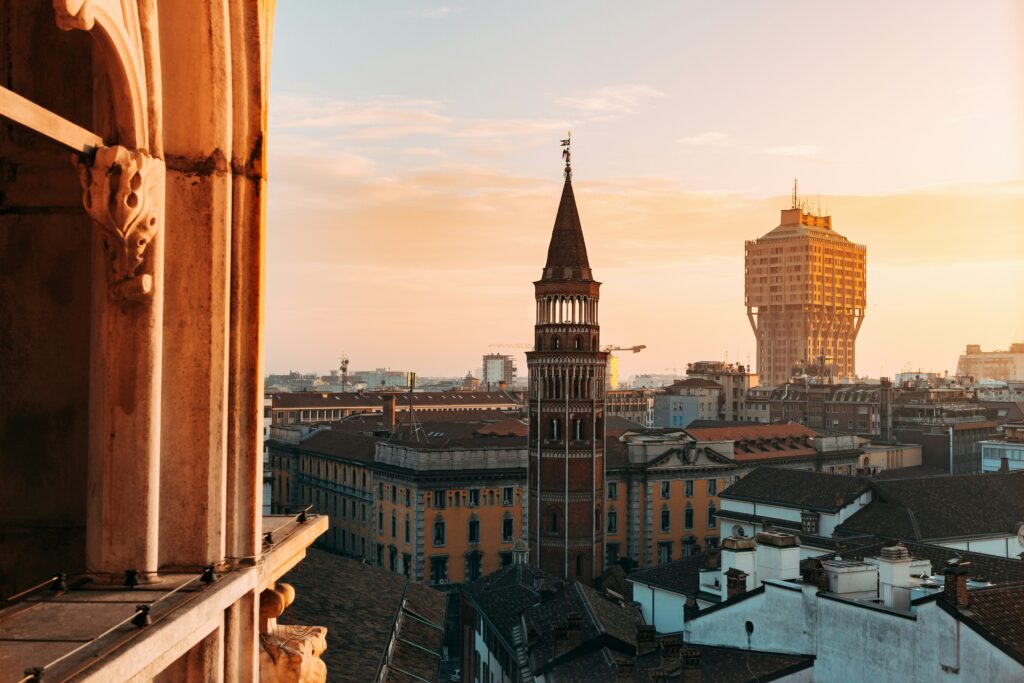 Milan sunset cityscape with iconic Velasca Tower and traditional terracotta roofed buildings